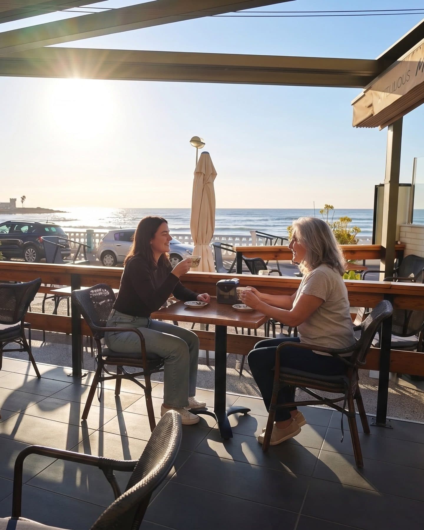 Dos amigas en la terraza de Mango Beach House al atardecer, con el mar de fondo, Torrevieja