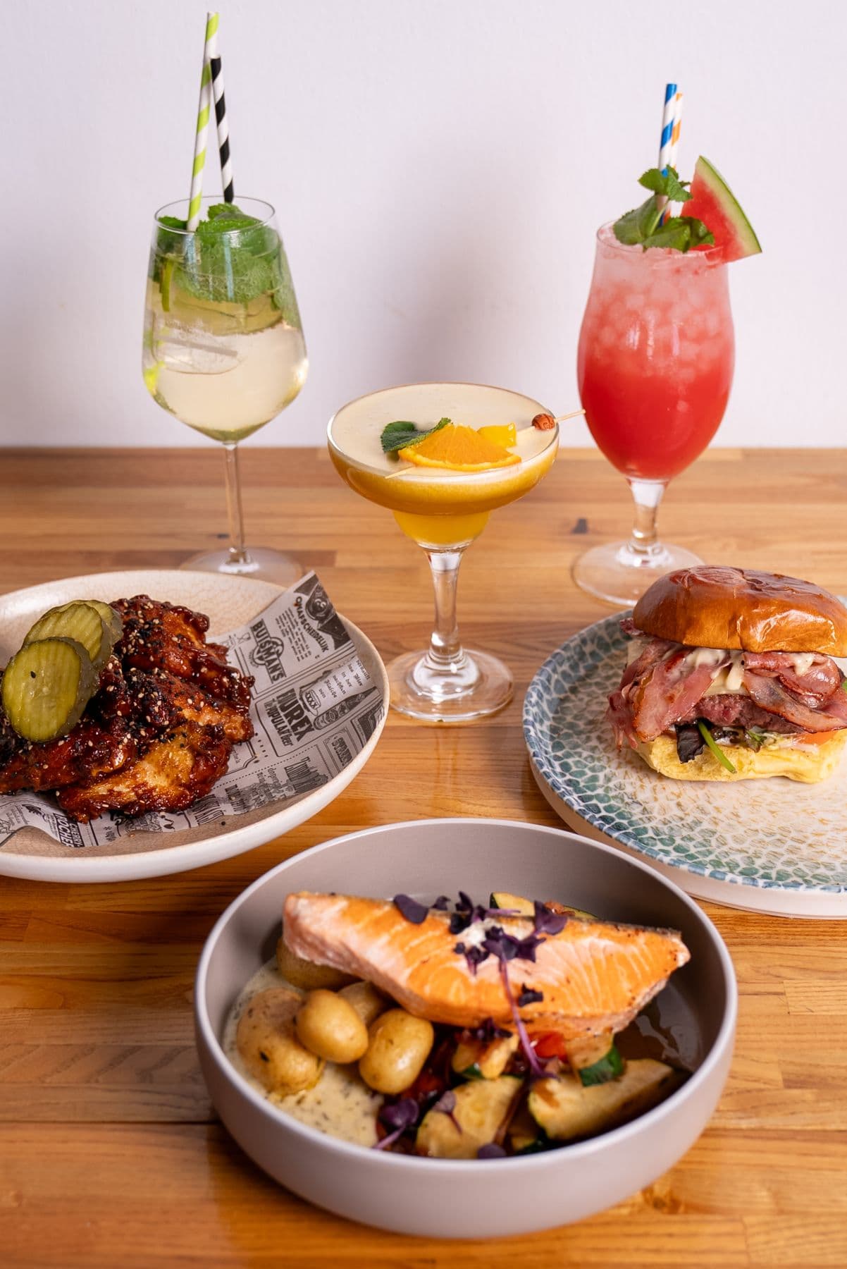 Mesa servida con platos y cócteles de la carta de Mango Beach House, Torrevieja